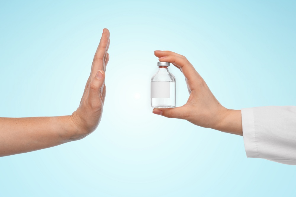 medicine, vaccination and healthcare concept - hand of doctor with drug in bottle and patient showing stop gesture over blue background. hand with medicine and showing stop gesture