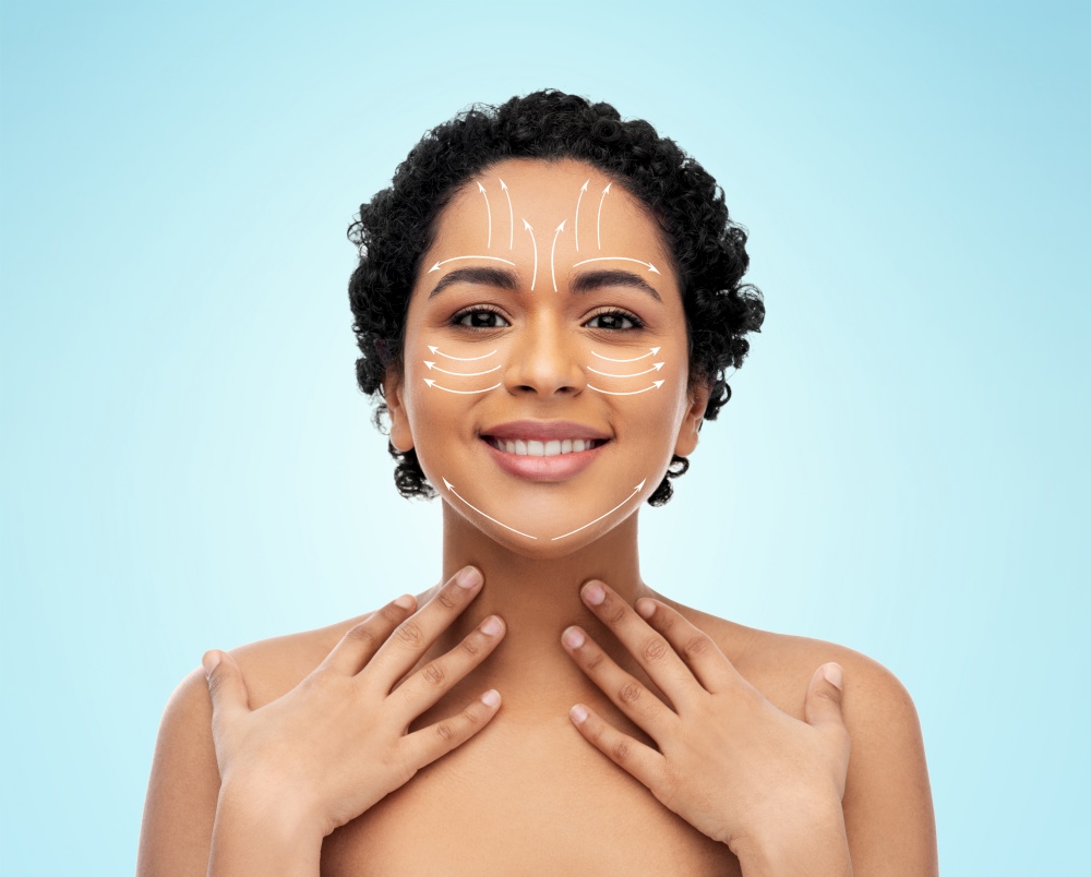 beauty, plastic surgery and people concept - happy smiling young african american woman with arrows on face over blue background. young african american woman with arrows on face