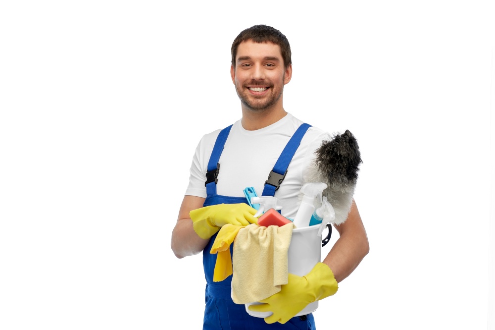 profession, service and people concept - happy smiling male worker or cleaner in overall and gloves with cleaning supplies over white background. male cleaner in overall with cleaning supplies