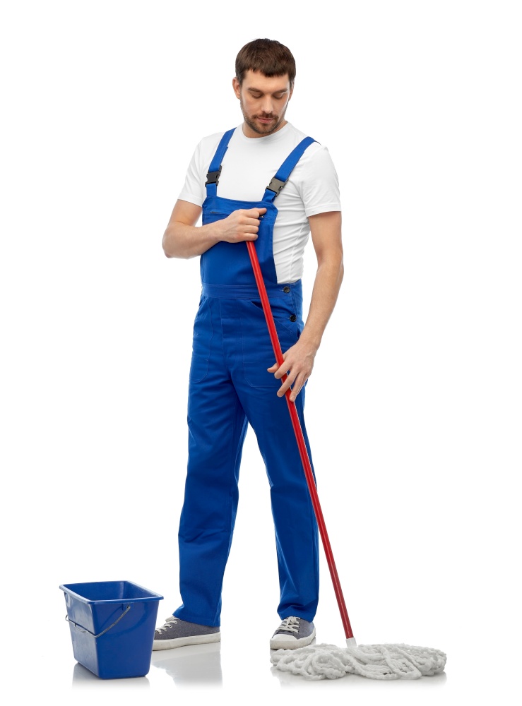 profession, service and people concept - male worker or cleaner in overall cleaning floor with wet mop and bucket over white background. male cleaner cleaning floor with mop and bucket