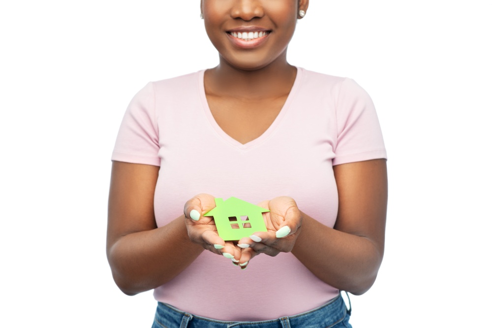 eco living, environment and sustainability concept - happy smiling young african american woman holding green house over white background. smiling african american woman holding green house
