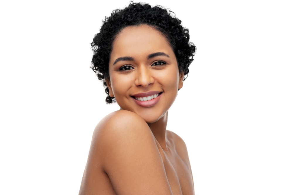 beauty and people concept - portrait of happy smiling young african american woman with bare shoulders over white background. portrait of young african american woman