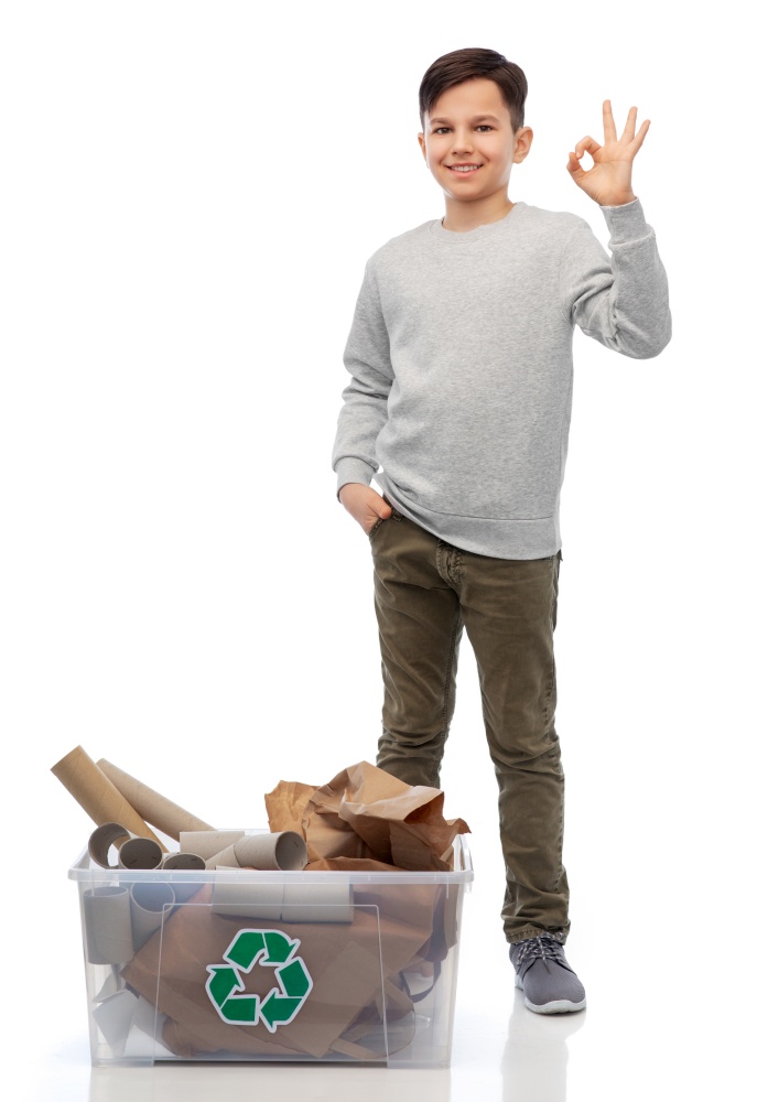recycling, waste sorting and sustainability concept - smiling boy with paper garbage in plastic box showing ok hand sign over white background. smiling boy sorting paper waste showing ok sign