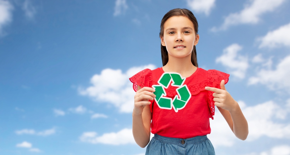 eco living, environment and sustainability concept - smiling girl holding green recycling sign over blue sky and clouds on background. smiling girl holding green recycling sign