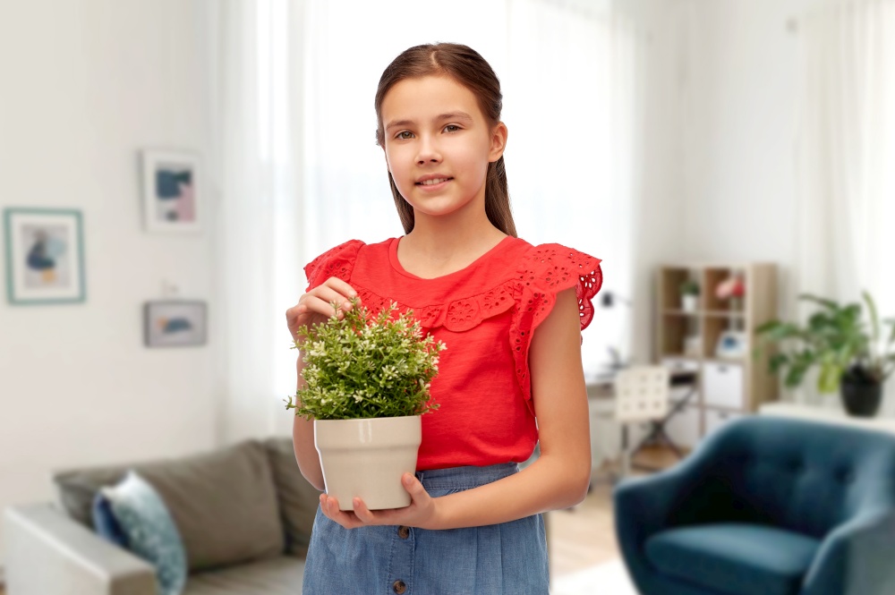 environment, nature and people concept - happy smiling girl holding flower in pot over home background. happy smiling girl holding flower in pot at home