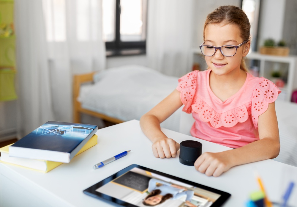 online education, e-learning and technology concept - student girl in glasses with smart speaker and teacher on tablet computer screen having video class at home. girl with smart speaker learning online at home