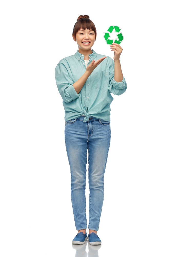 eco living, environment and sustainability concept - portrait of happy smiling young asian woman in turquoise shirt holding green recycling sign over white background. smiling asian woman holding green recycling sign