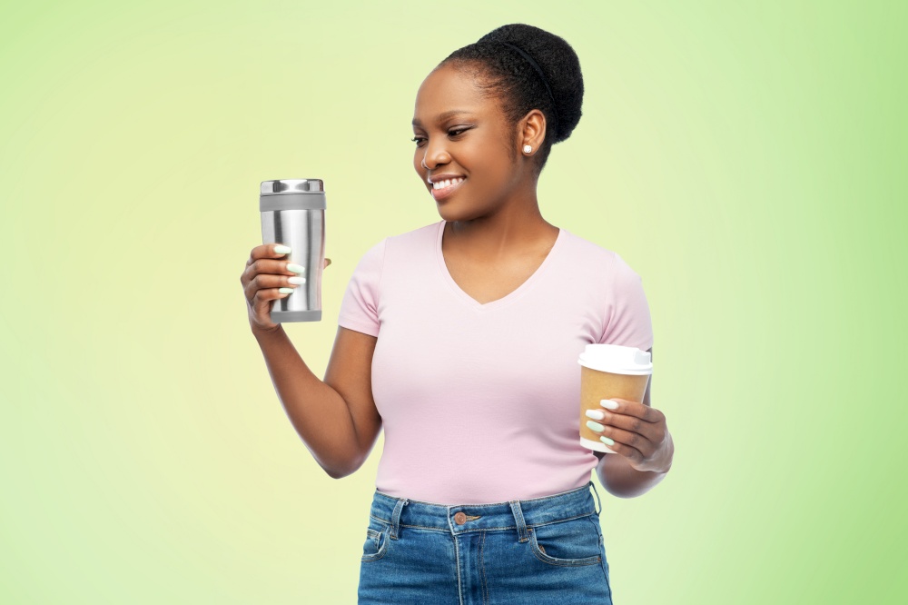 sustainability and people concept - portrait of happy smiling young african american woman with coffee cup and tumbler for hot drinks over green background. woman with coffee cup and tumbler for hot drinks