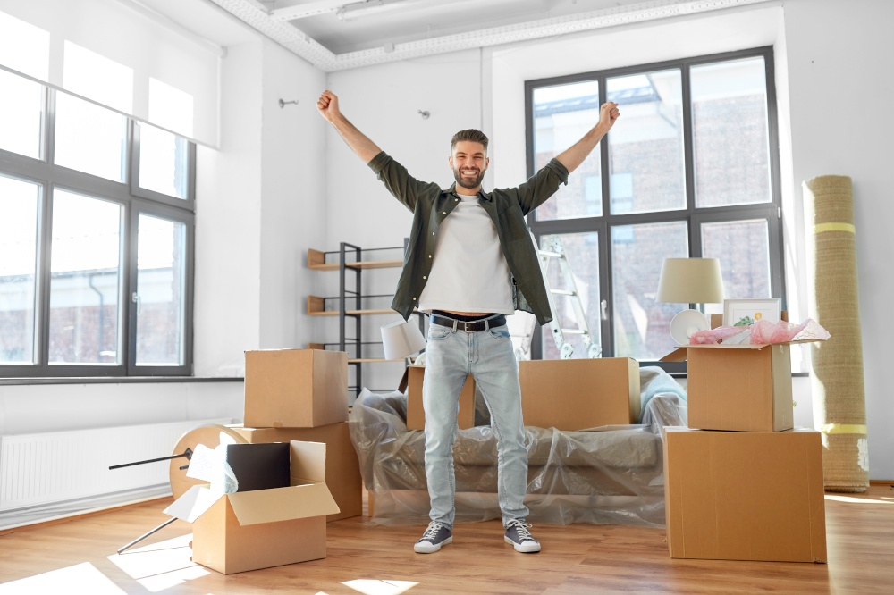 moving, people and real estate concept - happy smiling man with boxes at new home. happy man with boxes moving to new home