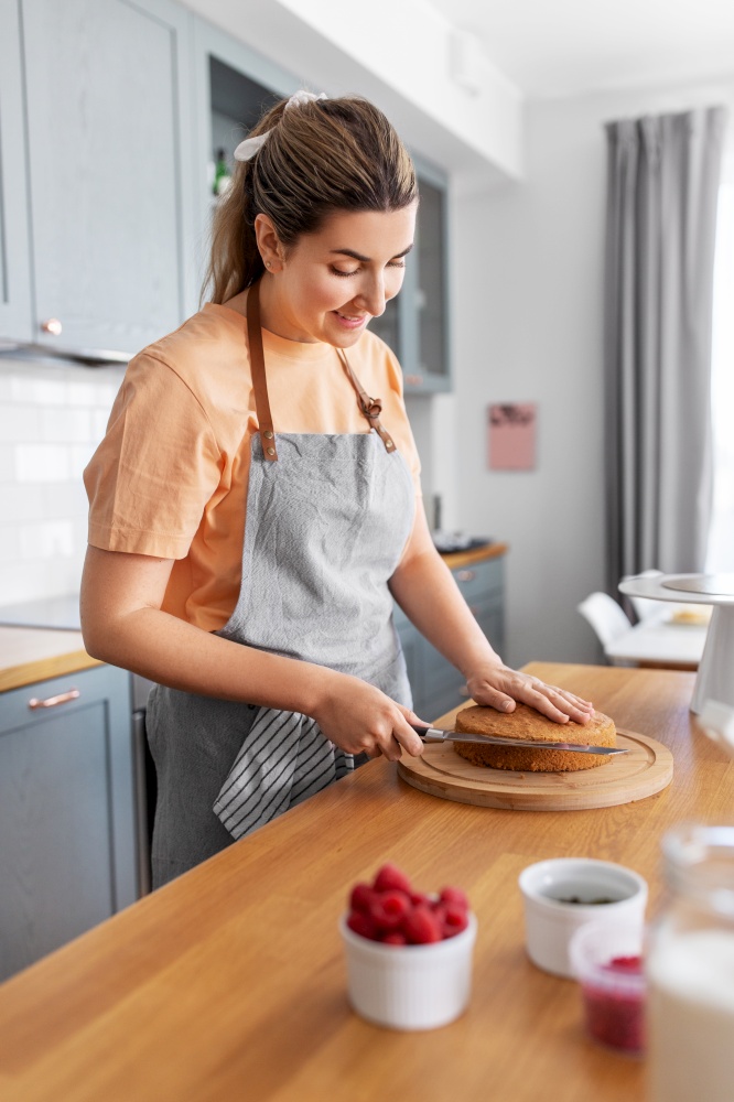 culinary, baking and cooking food concept - happy smiling young woman making cake on kitchen at home. woman cooking food and baking on kitchen at home