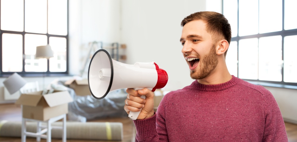 moving, real estate and people concept - smiling young man with megaphone talking over new home background. smiling man with megaphone talking over new home