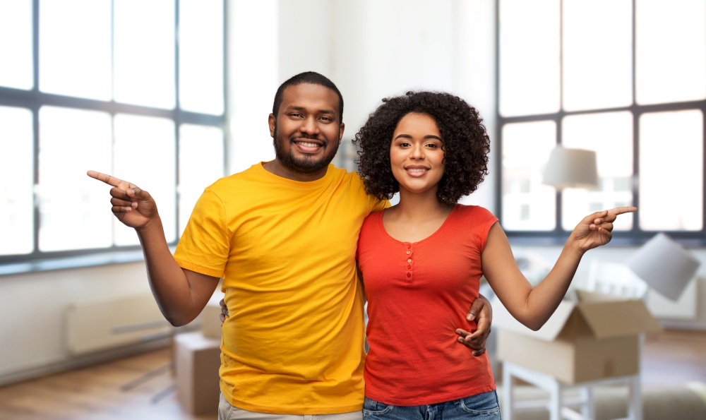 moving, real estate and people concept - happy african american couple over new home background. happy african american couple at new home