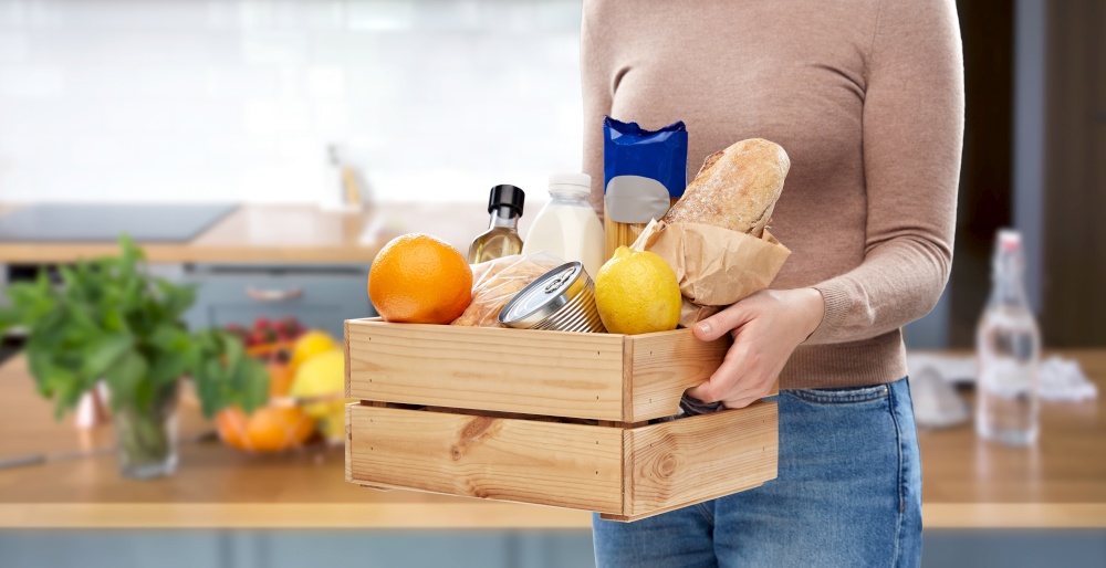 eating, grocery and delivery concept - close up of woman with food in wooden box over home kitchen background. close up of woman with food in wooden box