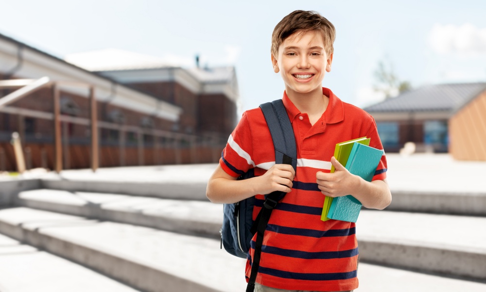 school, education and people concept - smiling student boy with backpack and books over city street background. smiling student boy with backpack and books