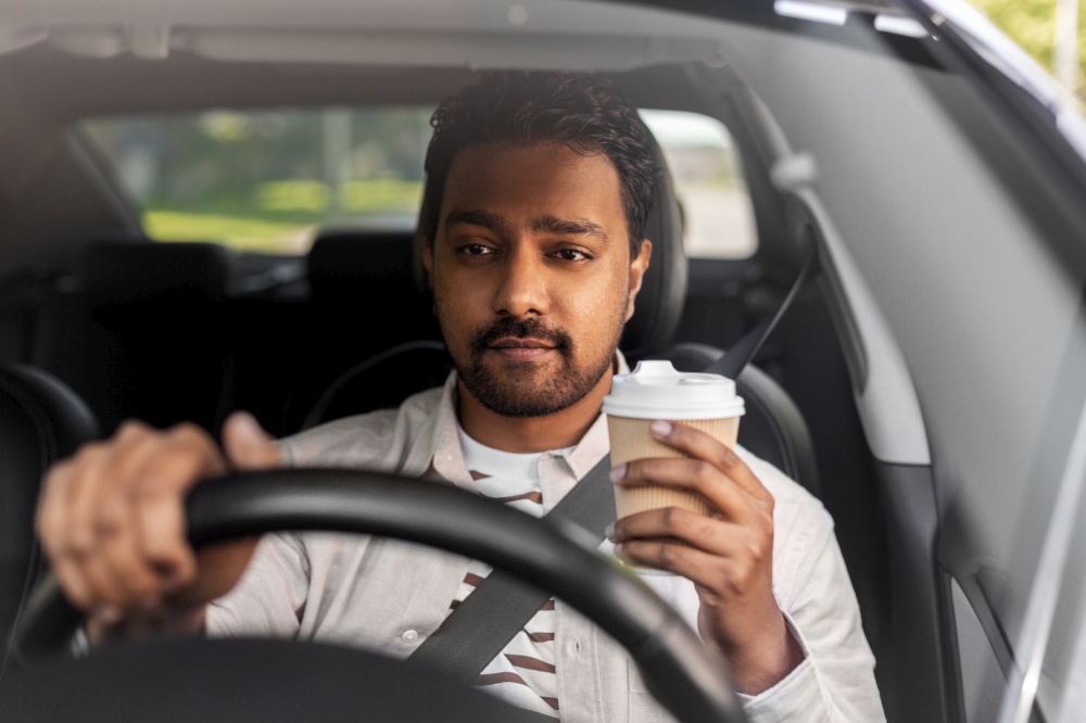 transport, vehicle and people concept - indian man or driver with takeaway coffee cup driving car. indian man or driver with coffee driving car