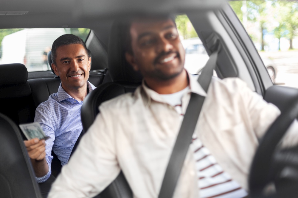 transportation, vehicle and payment concept - smiling passenger giving money to indian male taxi car driver. smiling passenger giving money to taxi car driver