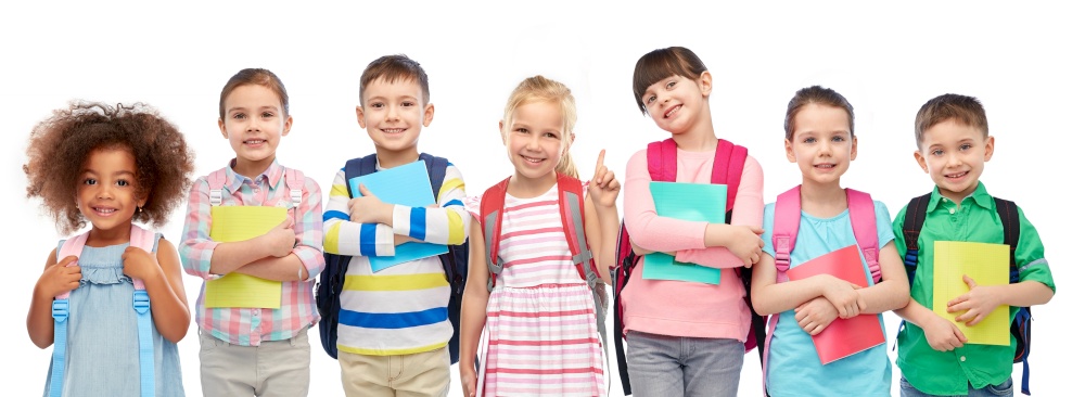education, learning and people concept - group of happy smiling little children with school bags and notebooks over white background. happy children with school bags and notebooks