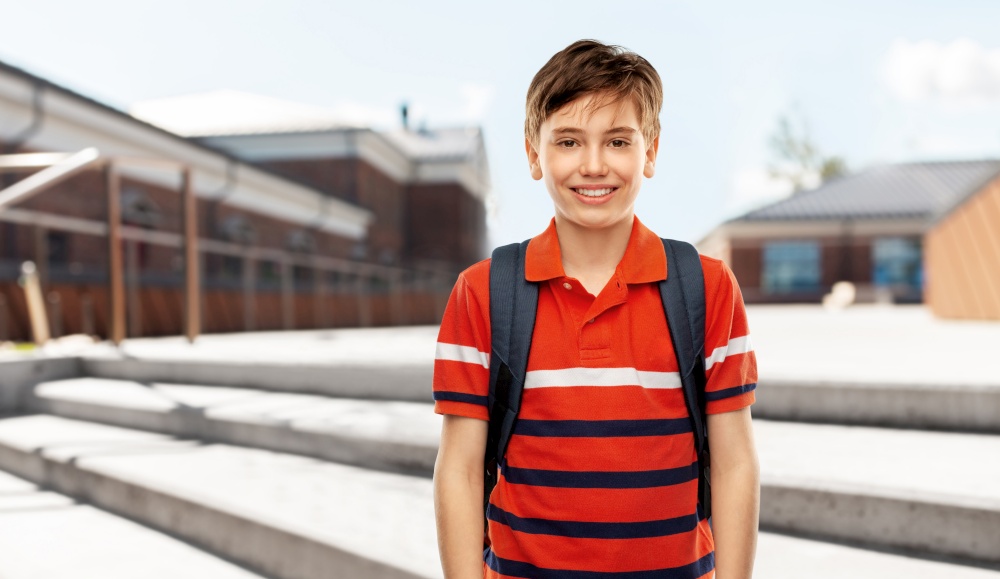 school, education and people concept - smiling student boy with backpack over city street background. smiling student boy with backpack