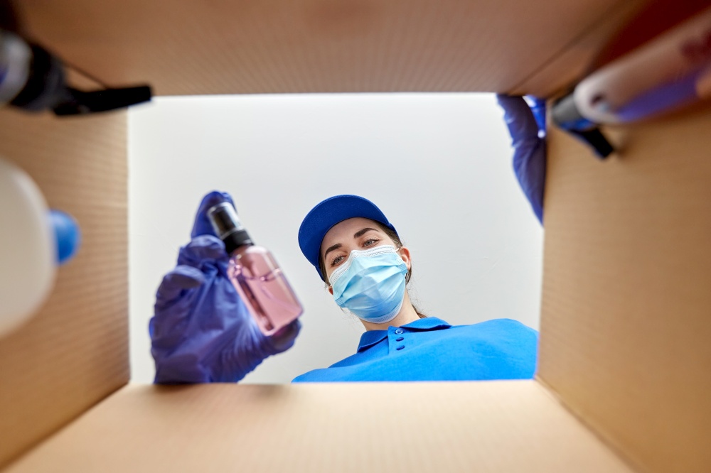 home delivery, shipping and pandemic concept - woman in protective medical mask and gloves packing parcel box with cosmetics and beauty products. woman in mask packing parcel box with cosmetics