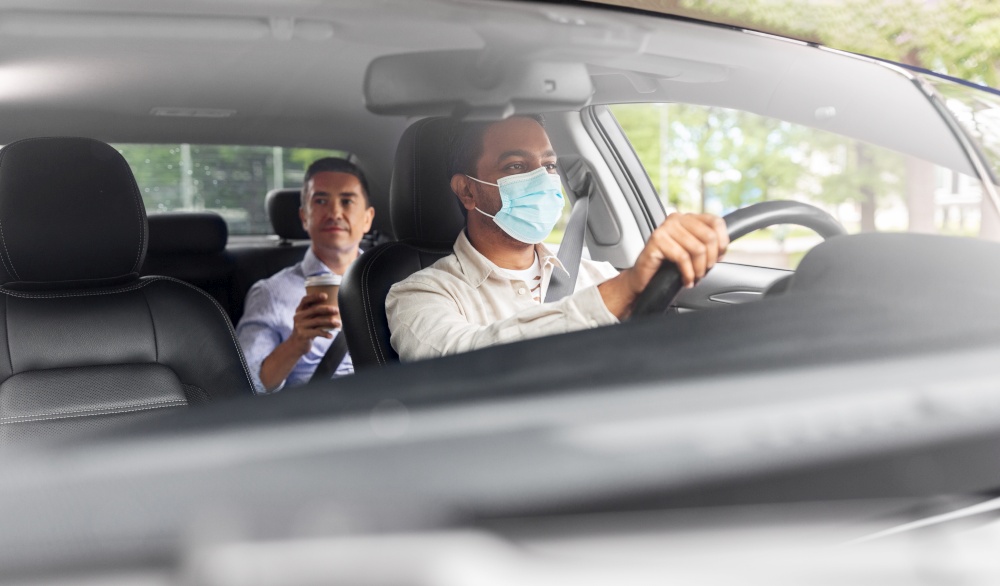 transportation, health and people concept - indian male taxi driver driving car with passenger wearing face protective medical mask for protection from virus disease. male driver in mask driving car with passenger