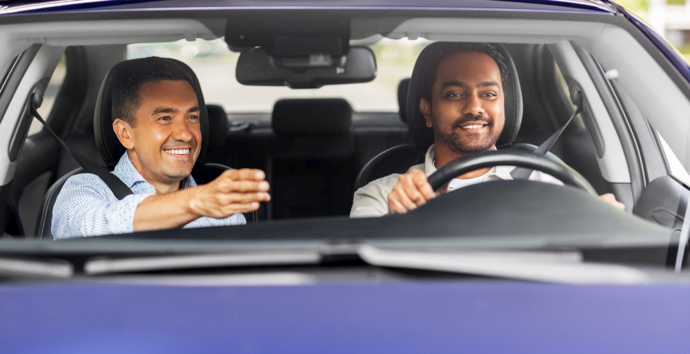 driver courses and people concept - happy smiling car driving school instructor teaching young man to drive. car driving school instructor teaching male driver