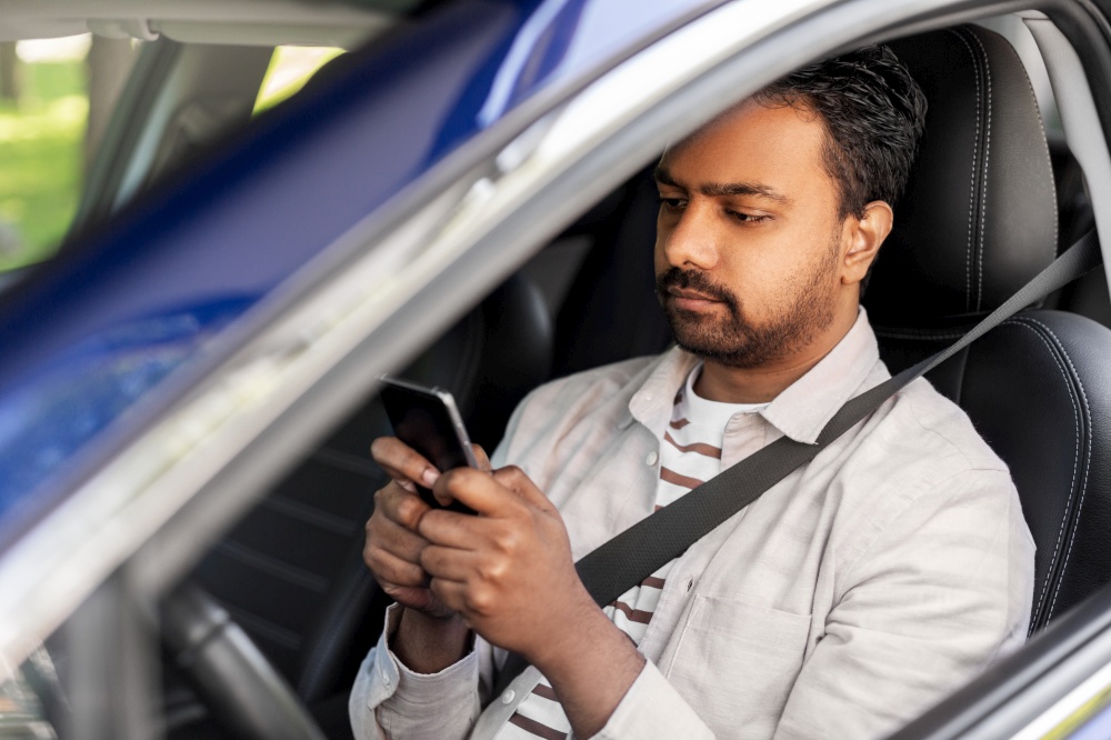 transport, people and technology concept - indian man or driver using smartphone in car. indian man in car using smartphone