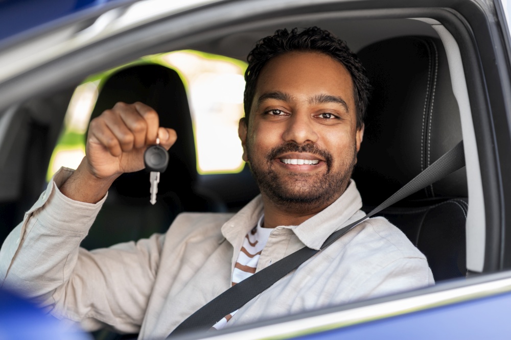 transport, vehicle and people concept - happy smiling indian man or driver showing car key. smiling indian man or driver showing car key