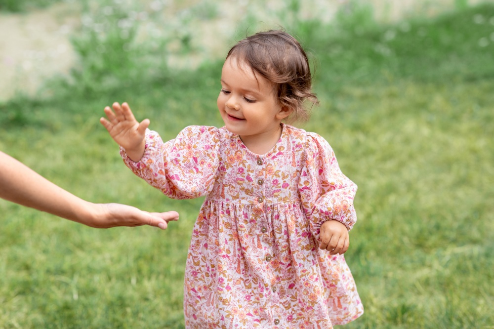 childhood, leisure and people concept - happy smiling little baby girl giving hand to adult. happy smiling baby girl giving hand to adult