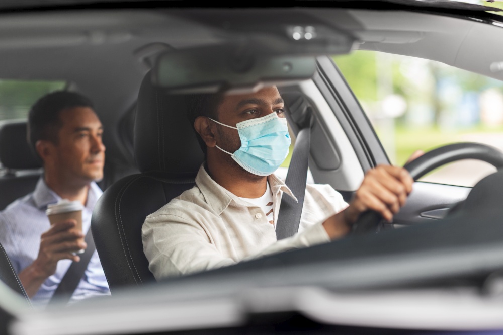 transportation, health and people concept - indian male taxi driver driving car with passenger wearing face protective medical mask for protection from virus disease. male driver in mask driving car with passenger