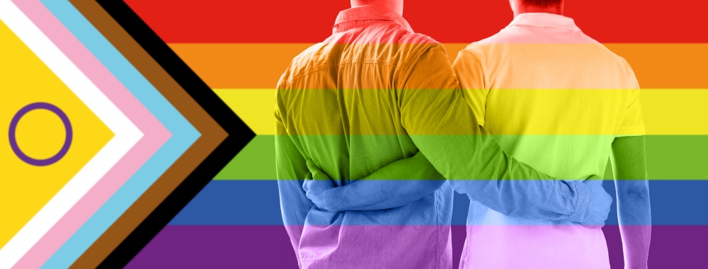 lgbtq, trans and intersex rights concept - close up of male gay couple hugging over rainbow progress pride flag on background. close up of male gay couple over pride flag