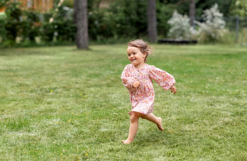 childhood, leisure and people concept - happy little baby girl running across summer field. happy little baby girl running across summer field