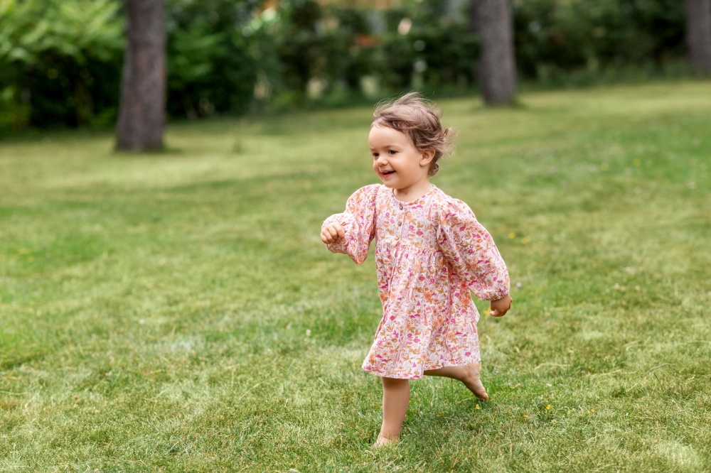 childhood, leisure and people concept - happy little baby girl running across summer field. happy little baby girl running across summer field