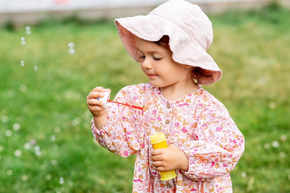 childhood, leisure and people concept - happy little baby girl blowing soap bubbles in summer. happy baby girl blowing soap bubbles in summer