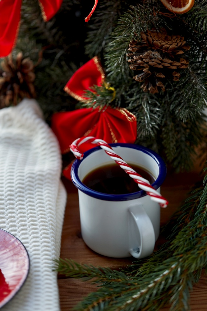 holidays, christmas and celebration concept - cup of black coffee with candy cane at home. cup of coffee with candy cane at home on christmas
