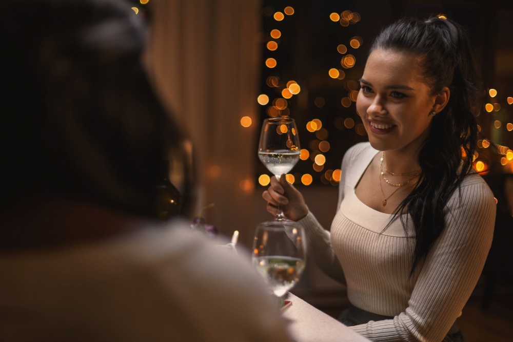 holidays and celebration concept - happy woman having christmas dinner at home and drinking white wine. happy woman drinking wine at christmas dinner