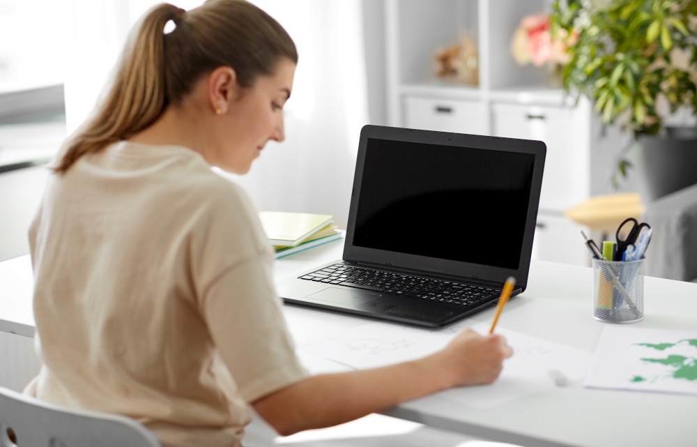 education, online school and distant learning concept - student woman with laptop computer drawing picture at home. student woman with laptop drawing picture at home