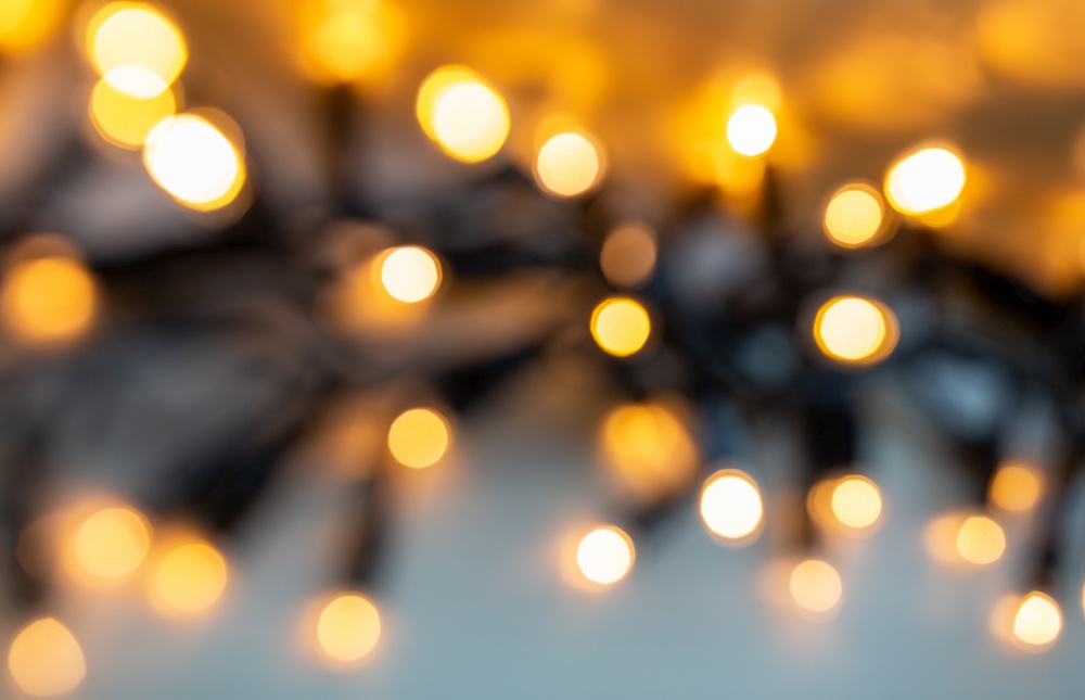 christmas, holidays and illumination concept - blurred electric garland lights. blurred electric garland lights