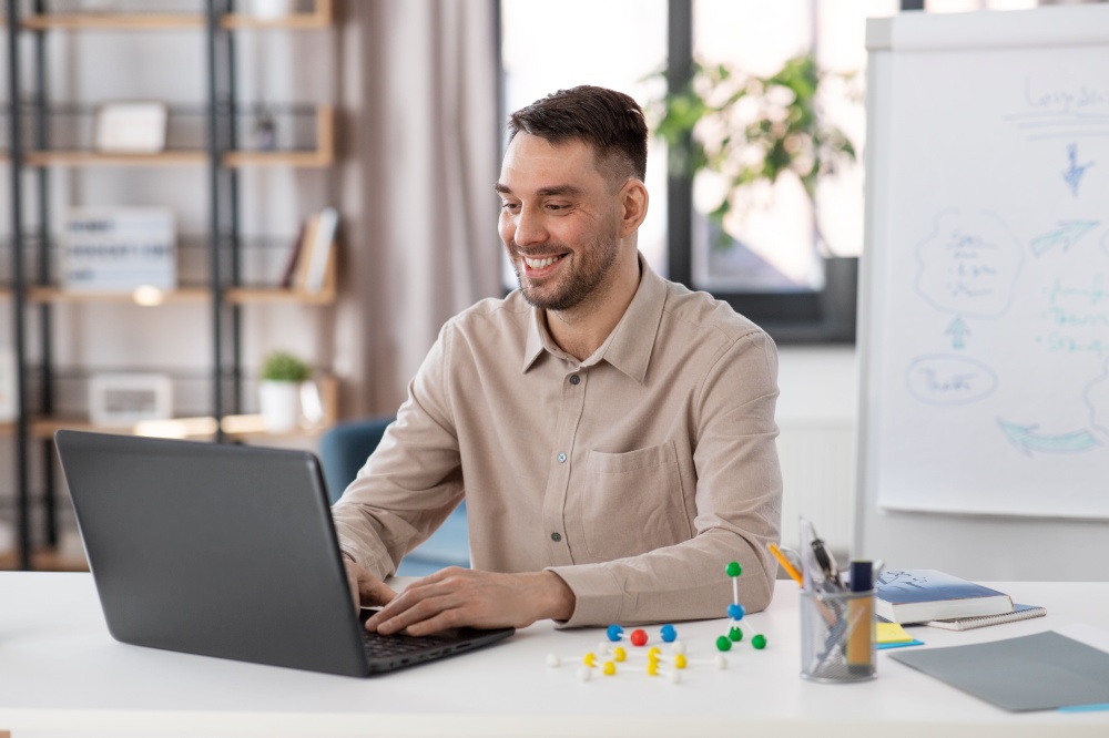 distant education, school and remote job concept - happy smiling male teacher with laptop working at home office. smiling male teacher with laptop working at home