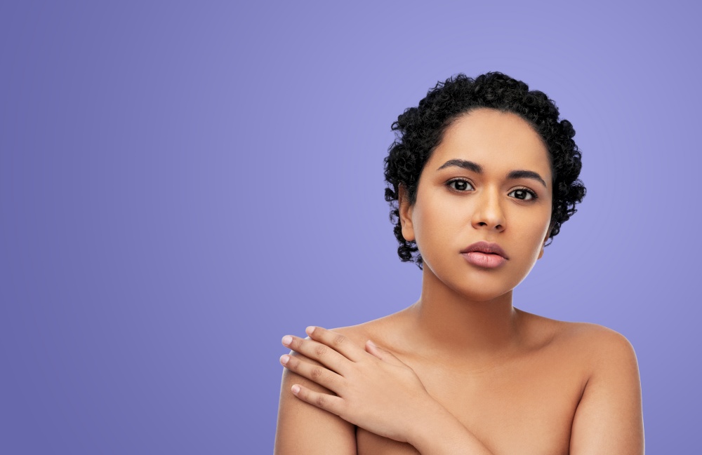 beauty and people concept - portrait of young african american woman with bare shoulders over violet background. portrait of young african american woman