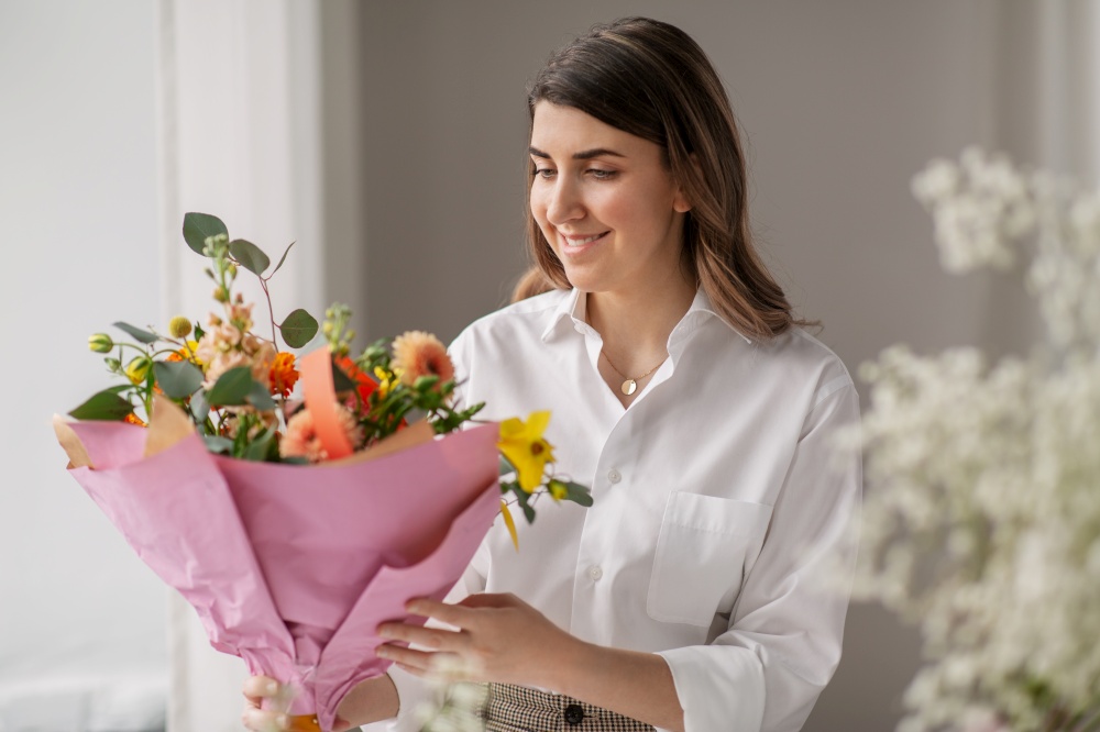 people, gardening and floral design concept - happy smiling woman or floral artist with bunch of flowers at home. happy woman with bunch of flowers at home