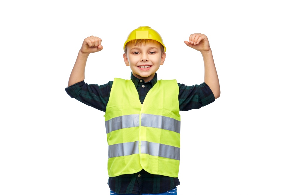 building, construction and profession concept - happy smiling little boy in protective helmet and safety vest showing power gesture over white background. boy in protective helmet showing power gesture