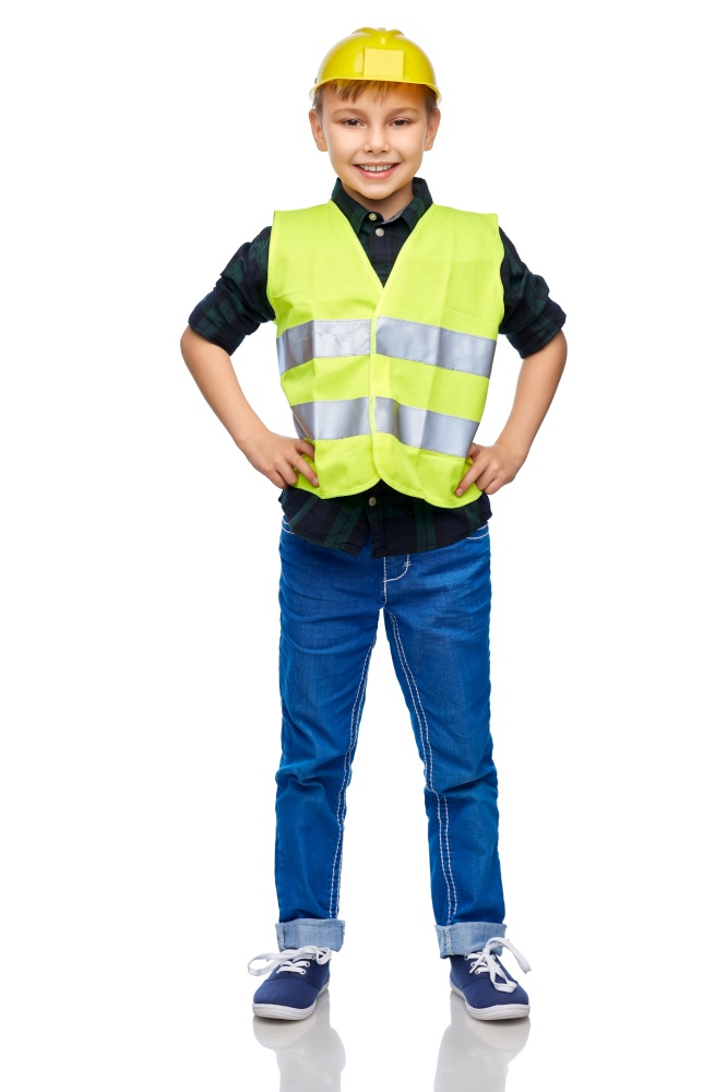 building, construction and profession concept - happy smiling little boy in protective helmet and safety vest over white background. little boy in protective helmet and safety vest