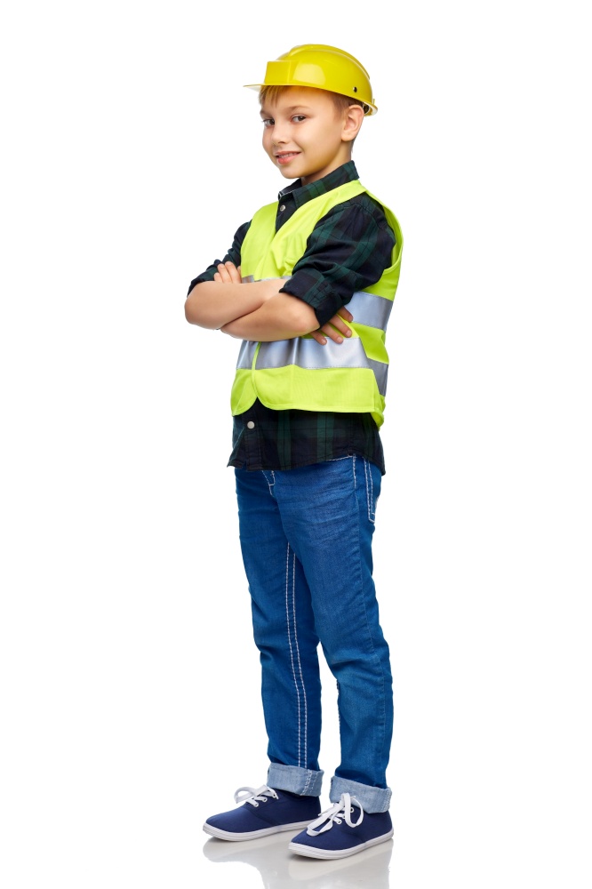 building, construction and profession concept - happy smiling little boy in protective helmet and safety vest with crossed arms over white background. little boy in protective helmet and safety vest