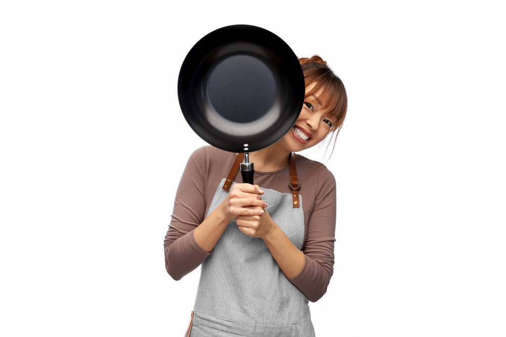 cooking, culinary and people concept - happy smiling female chef in apron with frying pan over white background. happy smiling female chef with frying pan