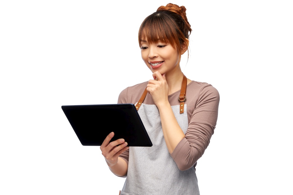 cooking, technology and people concept - happy smiling female chef or waitress in apron with tablet pc computer over white background. happy woman in apron with tablet pc computer