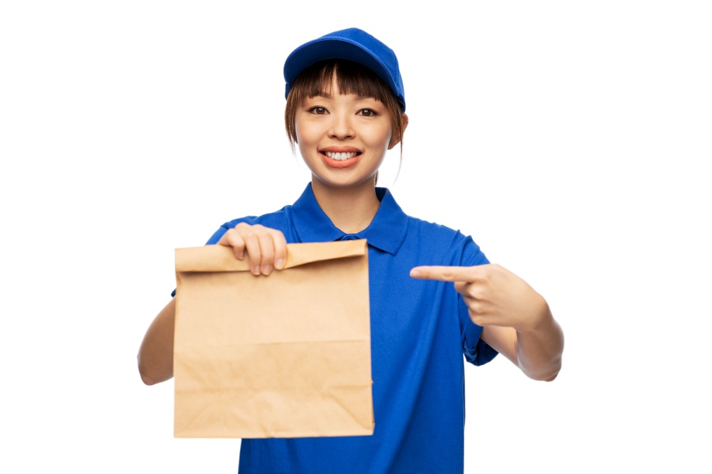 service and job concept - happy smiling delivery woman in blue uniform with takeaway food in paper bag over white background. delivery woman with takeaway food in paper bag