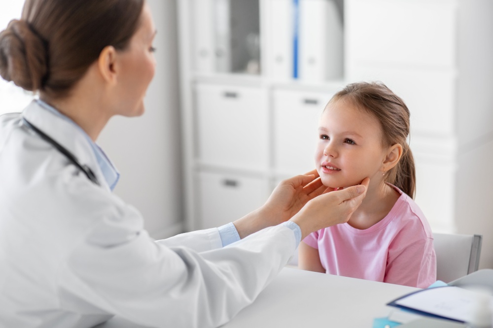 medicine, healthcare and pediatry concept - female doctor or pediatrician checking little girl patient&rsquo;s tonsils on medical exam at clinic. doctor checking girl patient&rsquo;s tonsils at clinic