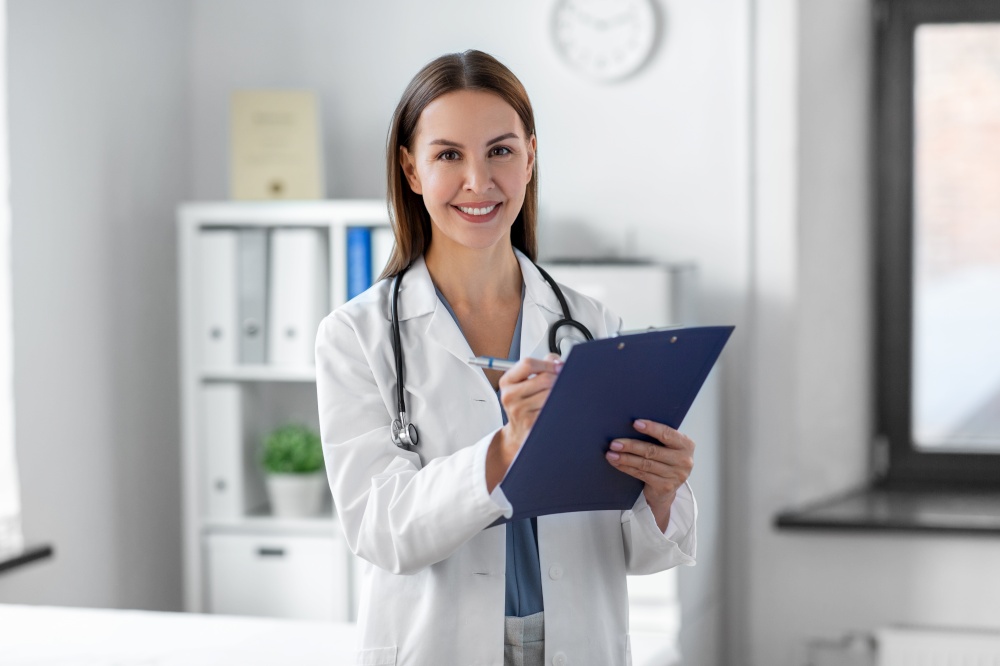 medicine, healthcare and profession concept - smiling female doctor with stethoscope and clipboard at hospital. smiling female doctor with clipboard at hospital