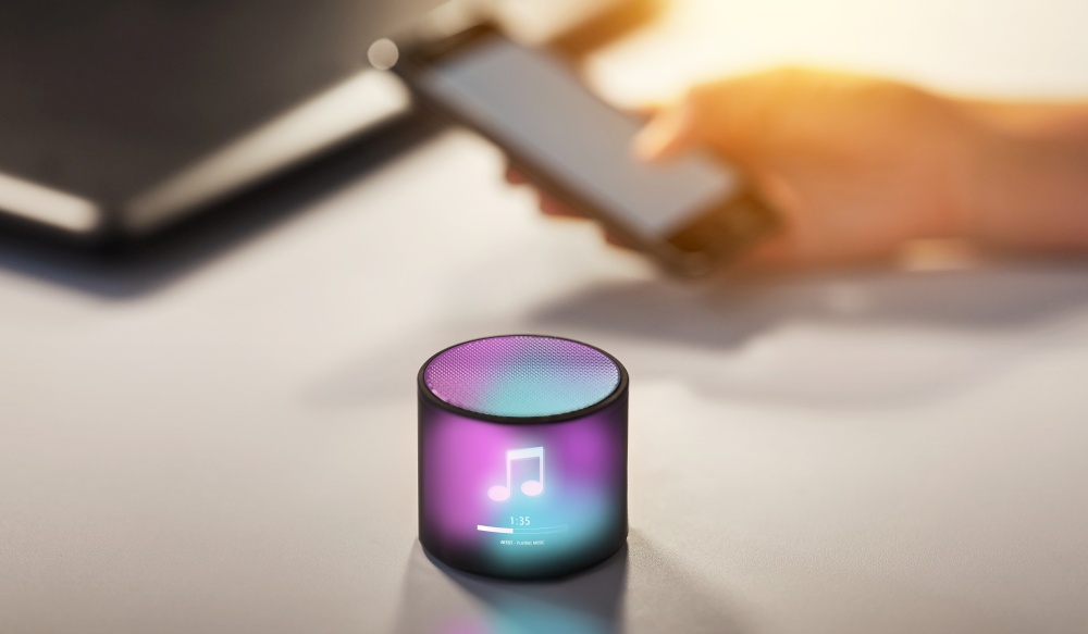 technology concept - smart speaker with virtual music note hologram on table at office. smart speaker with virtual music note hologram