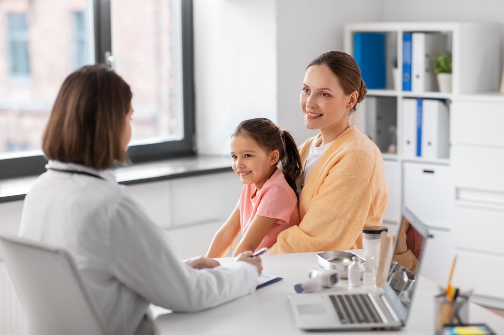 medicine, healthcare and pediatry concept - happy smiling mother with little daughter talking to doctor at clinic. mother with little daughter and doctor at clinic